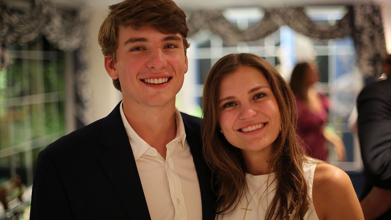 Guests in formal attire celebrating at an indoor event.