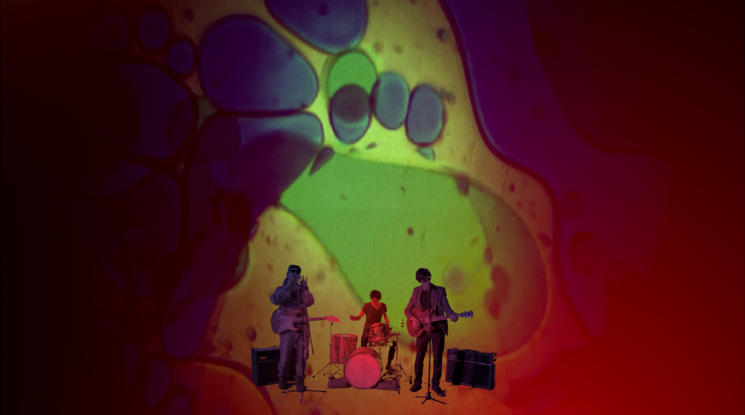 Musicians' silhouettes on stage with vibrant red and yellow lighting effects.