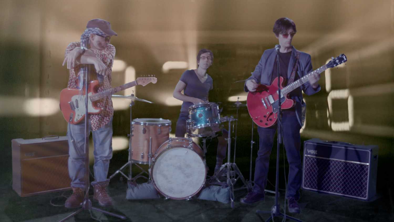 Musicians playing instruments on stage with dramatic lighting and shadows.