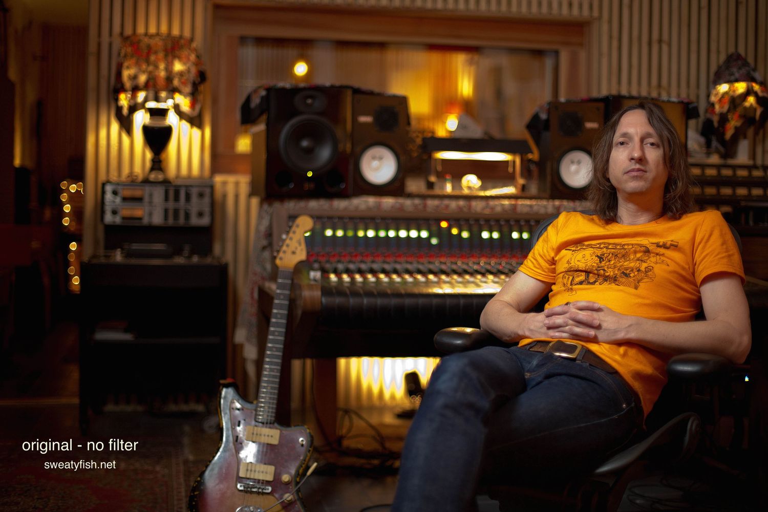 Recording studio interior with vintage wood paneling and warm lighting.