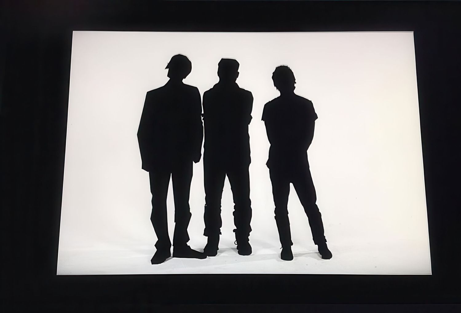 Black and white silhouettes of people standing against bright white background.