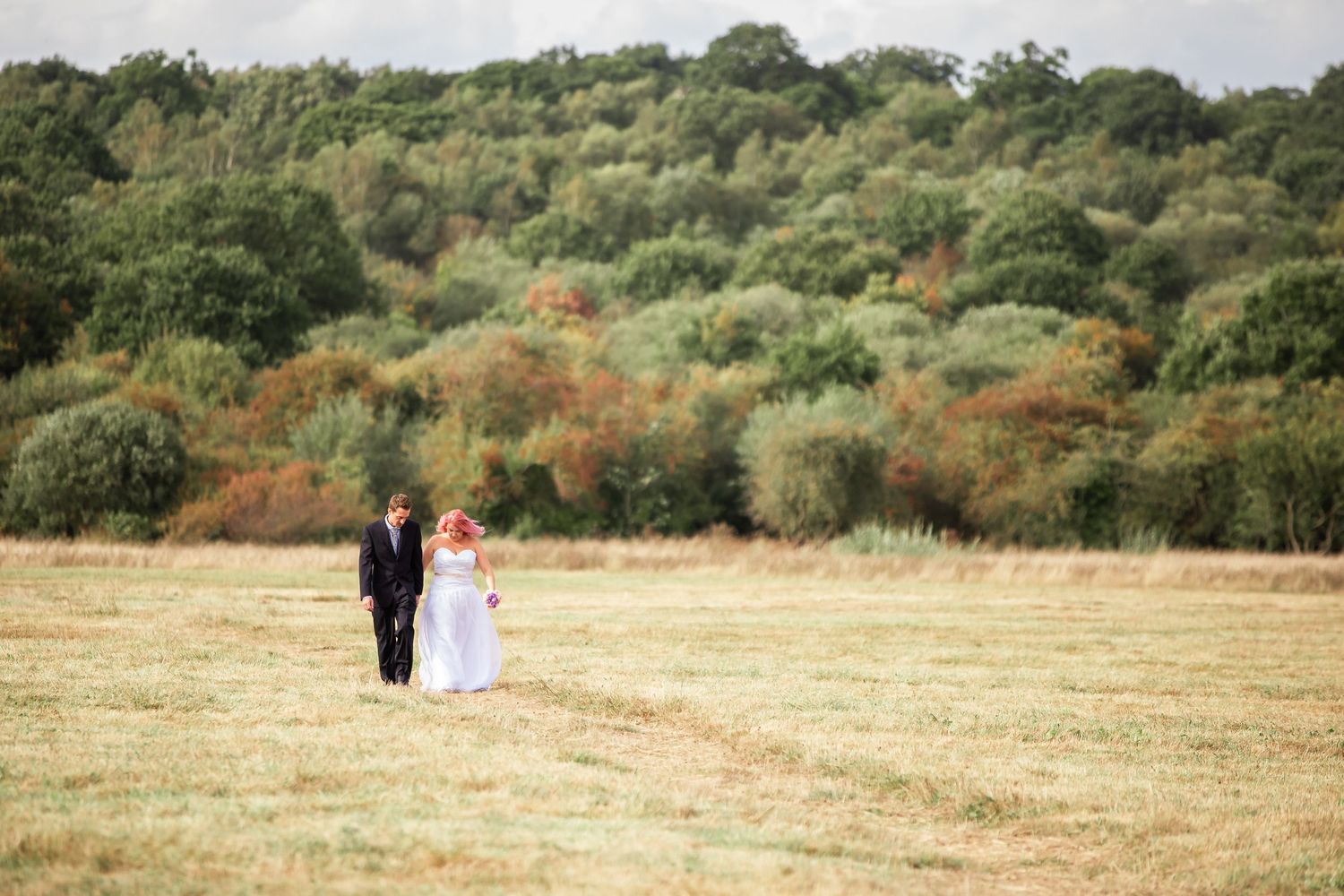 Natural wedding photos of couple walking hand in hand in Surrey garden venue