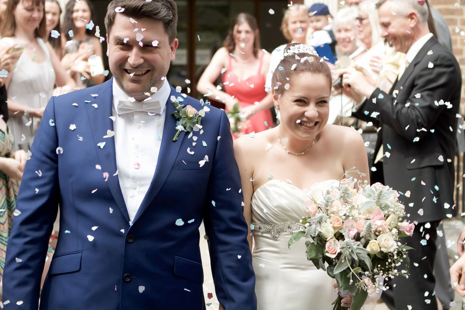 Guests cheering and throwing confetti at Surrey wedding ceremony exit. Wedding photographer, oliver charles photography
