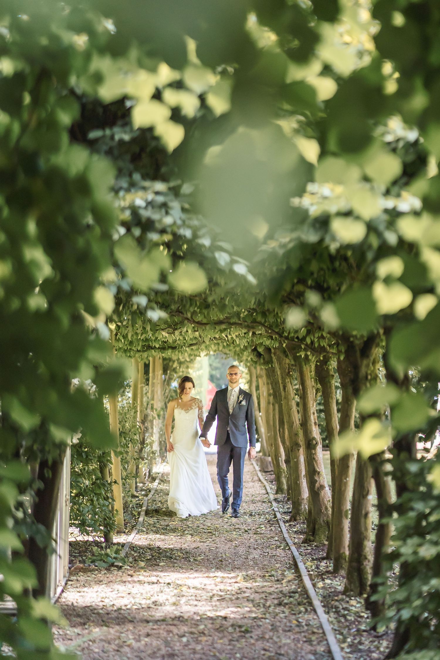 Natural wedding photography of couple walking through leaves barn venue in Surrey