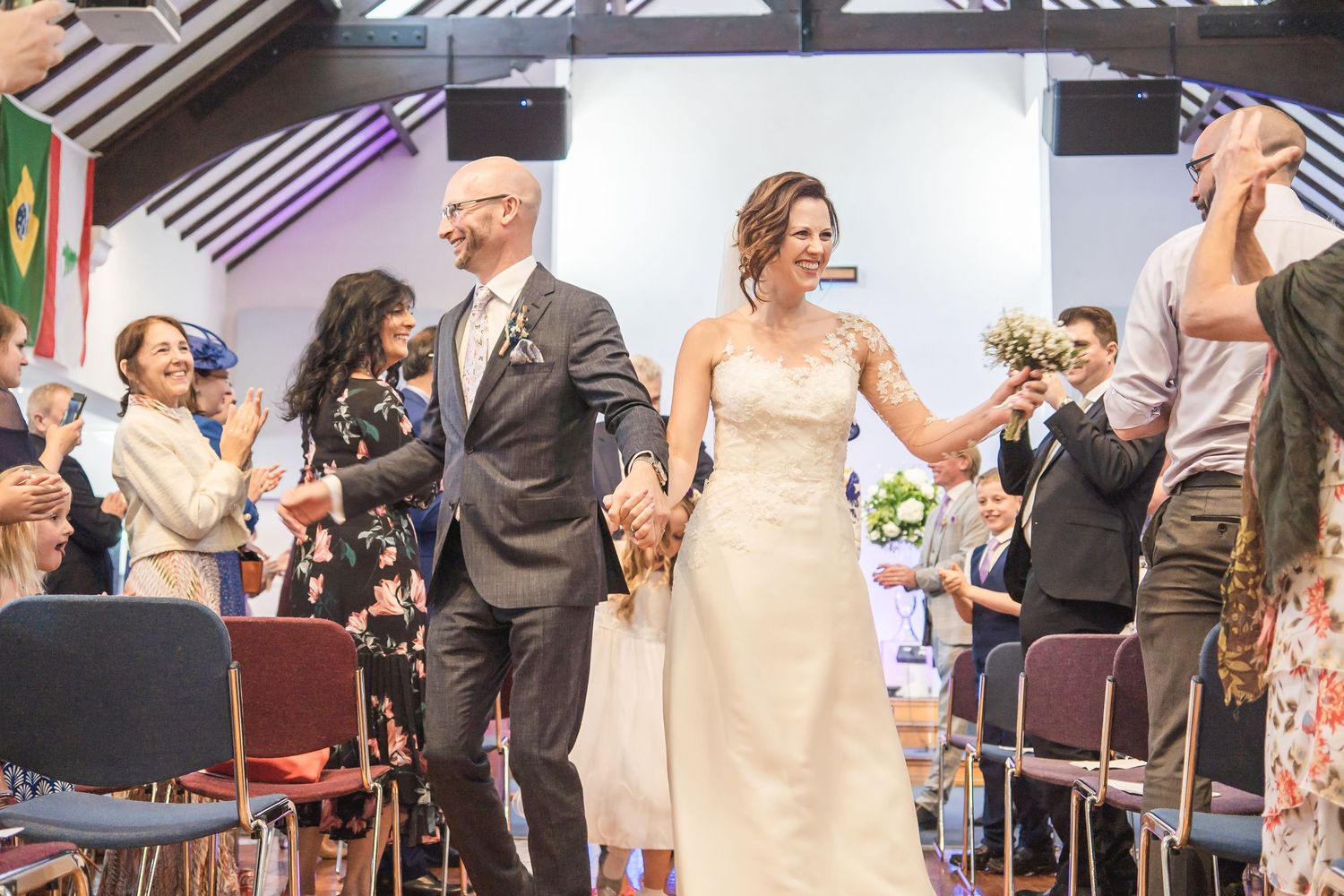 Bride and groom laughing during Surrey wedding ceremony captured by Surrey wedding photographer