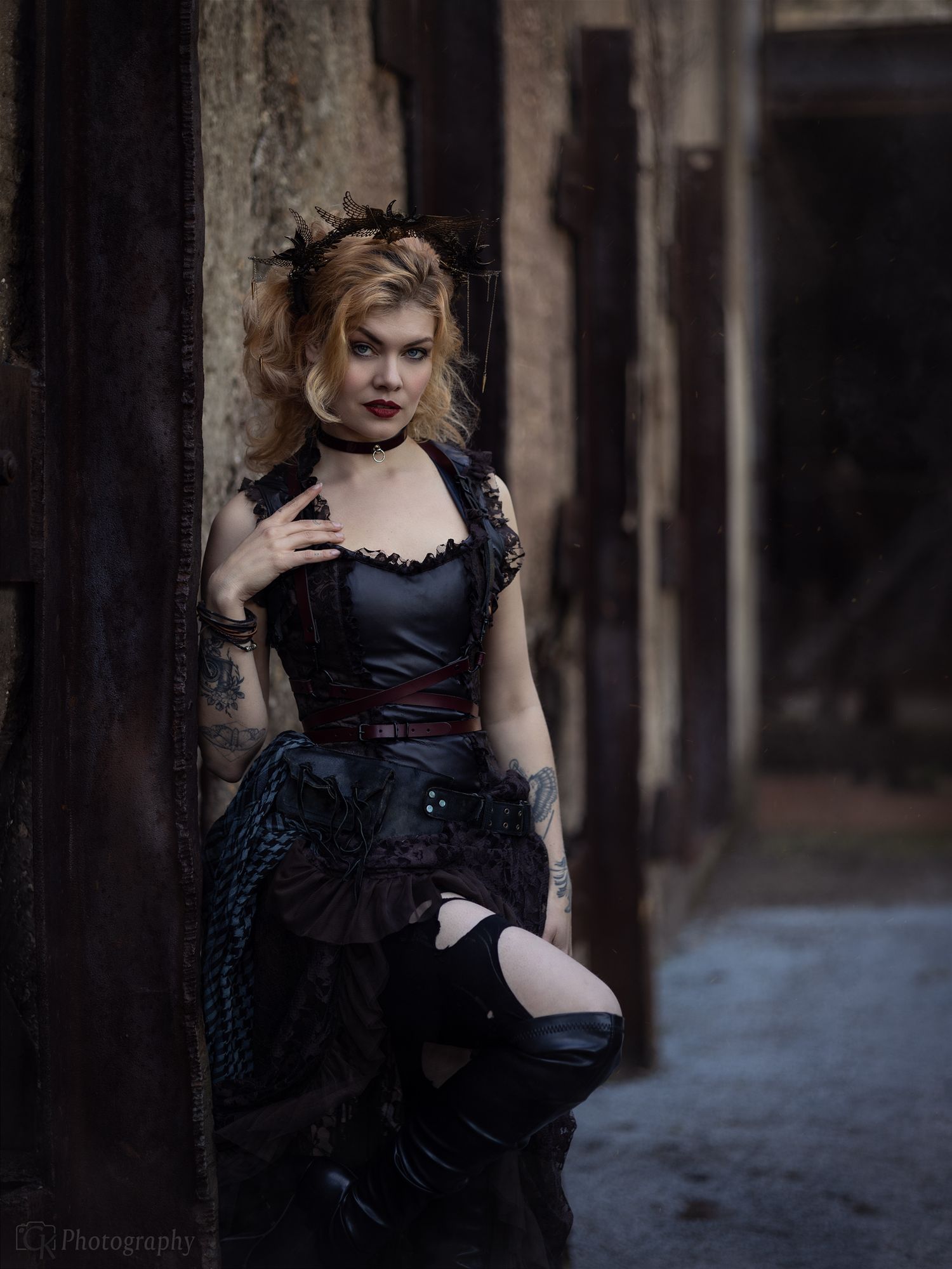 Creatieve portretfoto van een model in steampunk kleding tegen een industriële achtergrond van een verlaten staalfabriek