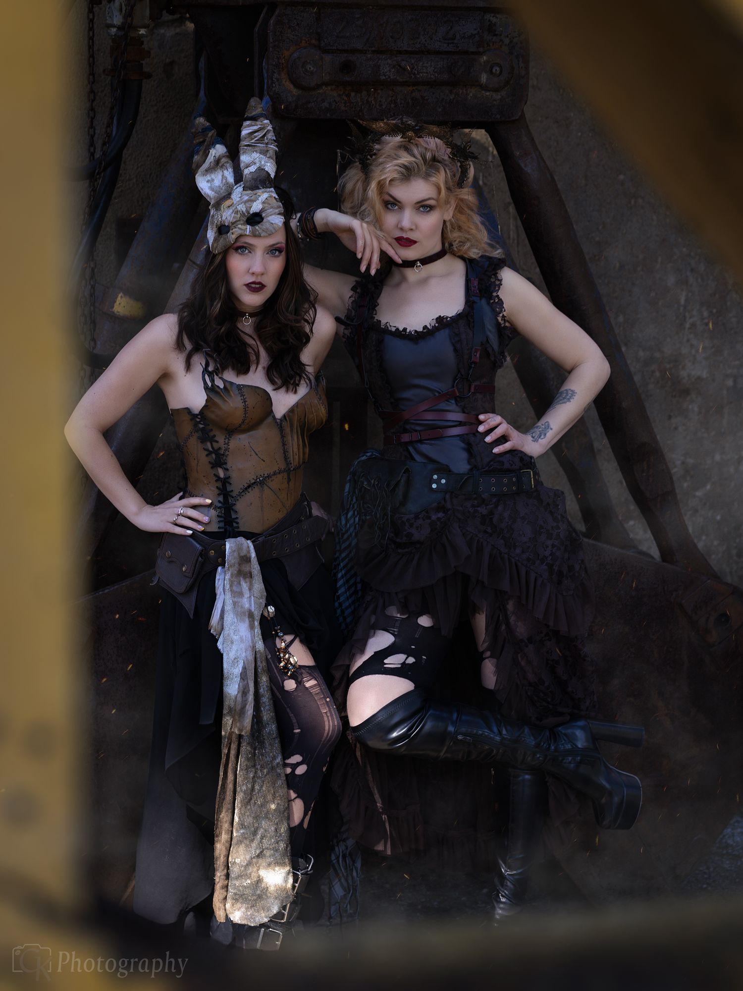 Creatieve portretfoto van een modellen in steampunk kleding tegen een industriële achtergrond van een verlaten staalfabriek