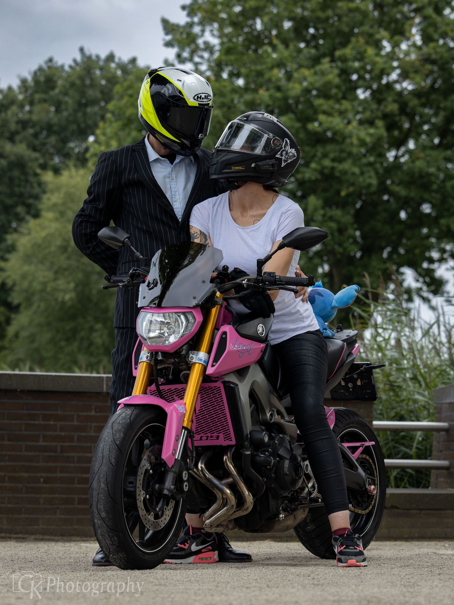 Koppel met motor tijdens een avontuurlijke fotoshoot, samen genieten van vrijheid en liefde op de weg