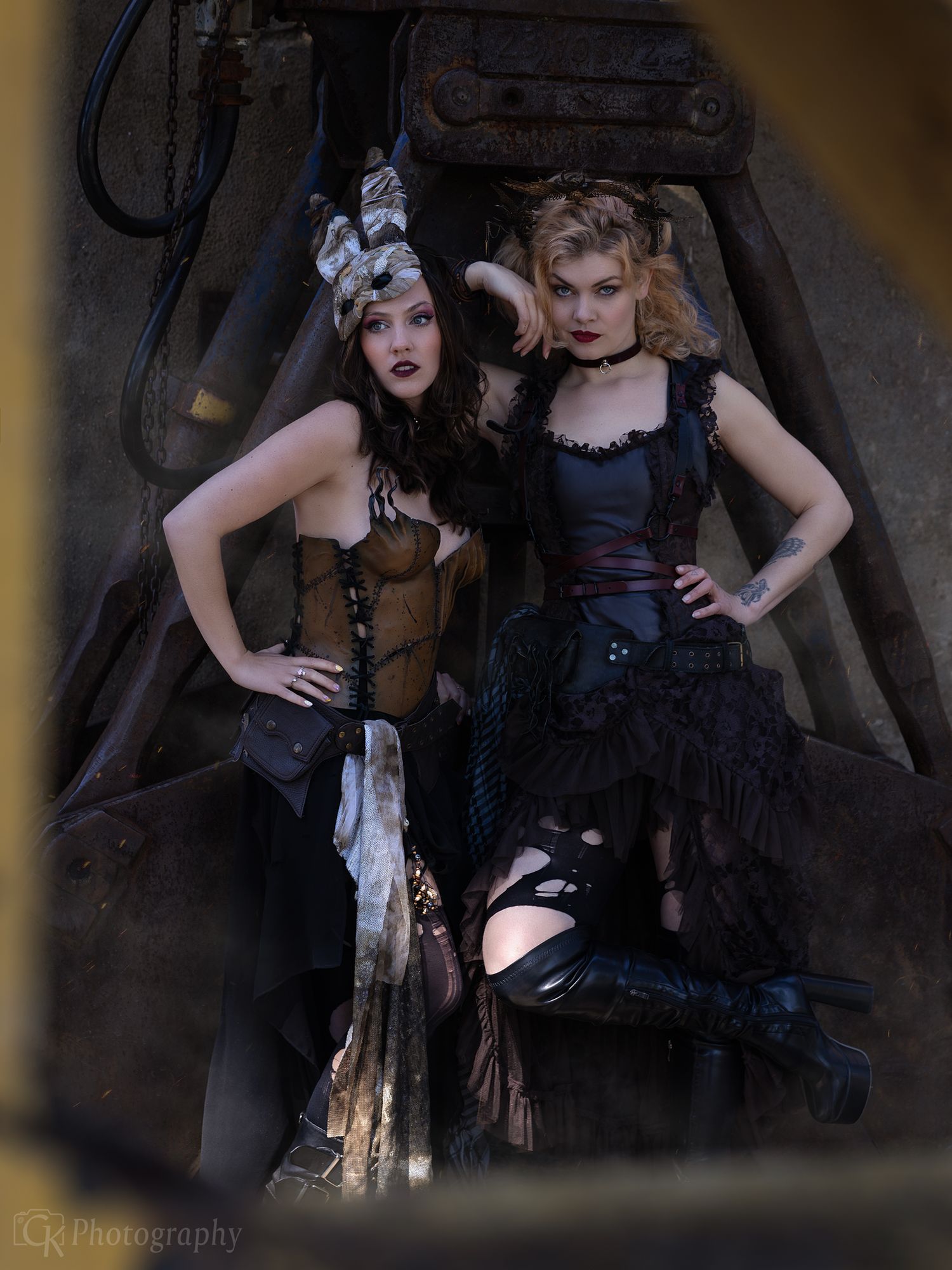 Creatieve portretfoto van een modellen in steampunk kleding tegen een industriële achtergrond van een verlaten staalfabriek