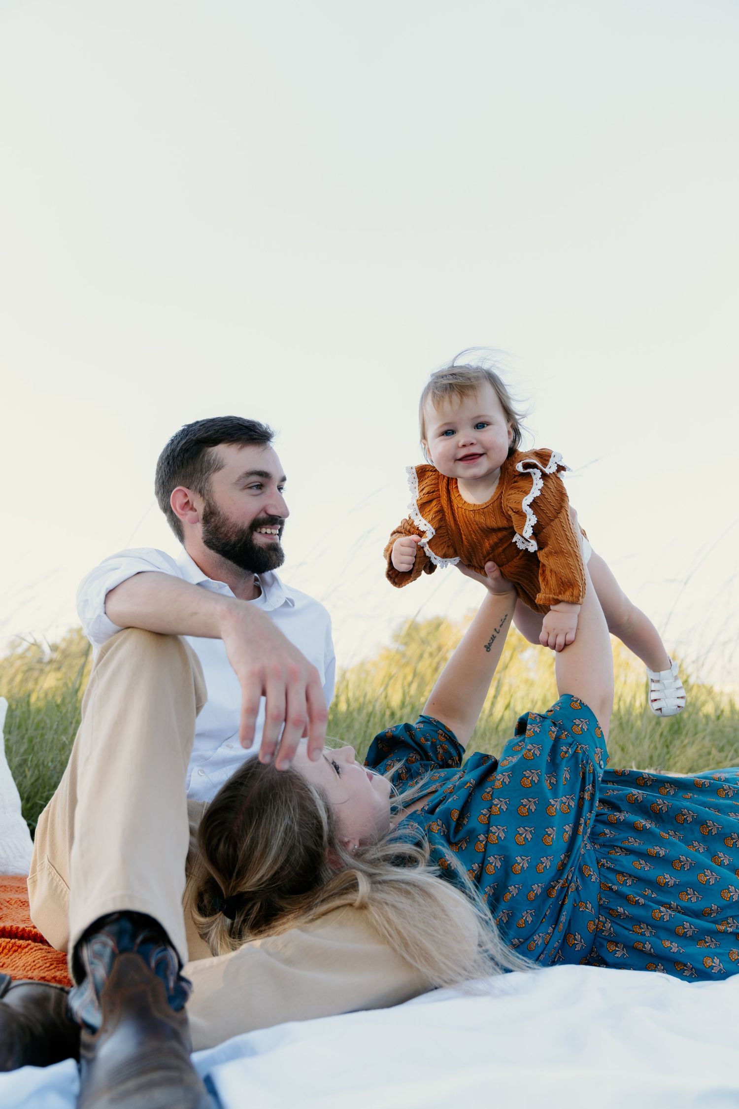 Family playing together on a bright sunny day in casual attire with playful expressions.