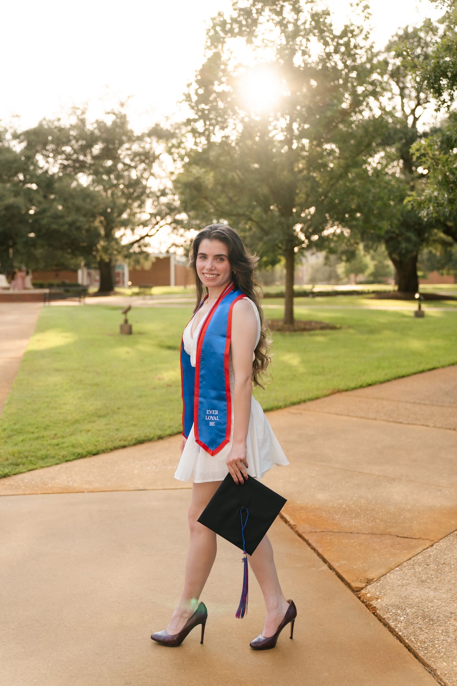 Outdoor photoshoot on a paved path during golden hour wearing red and blue attire.