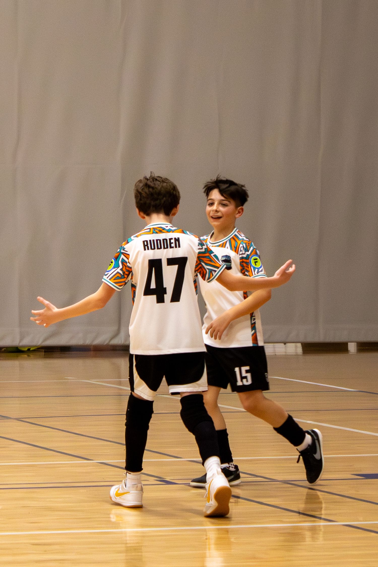 Youth basketball players celebrating and showing excitement on the court.
