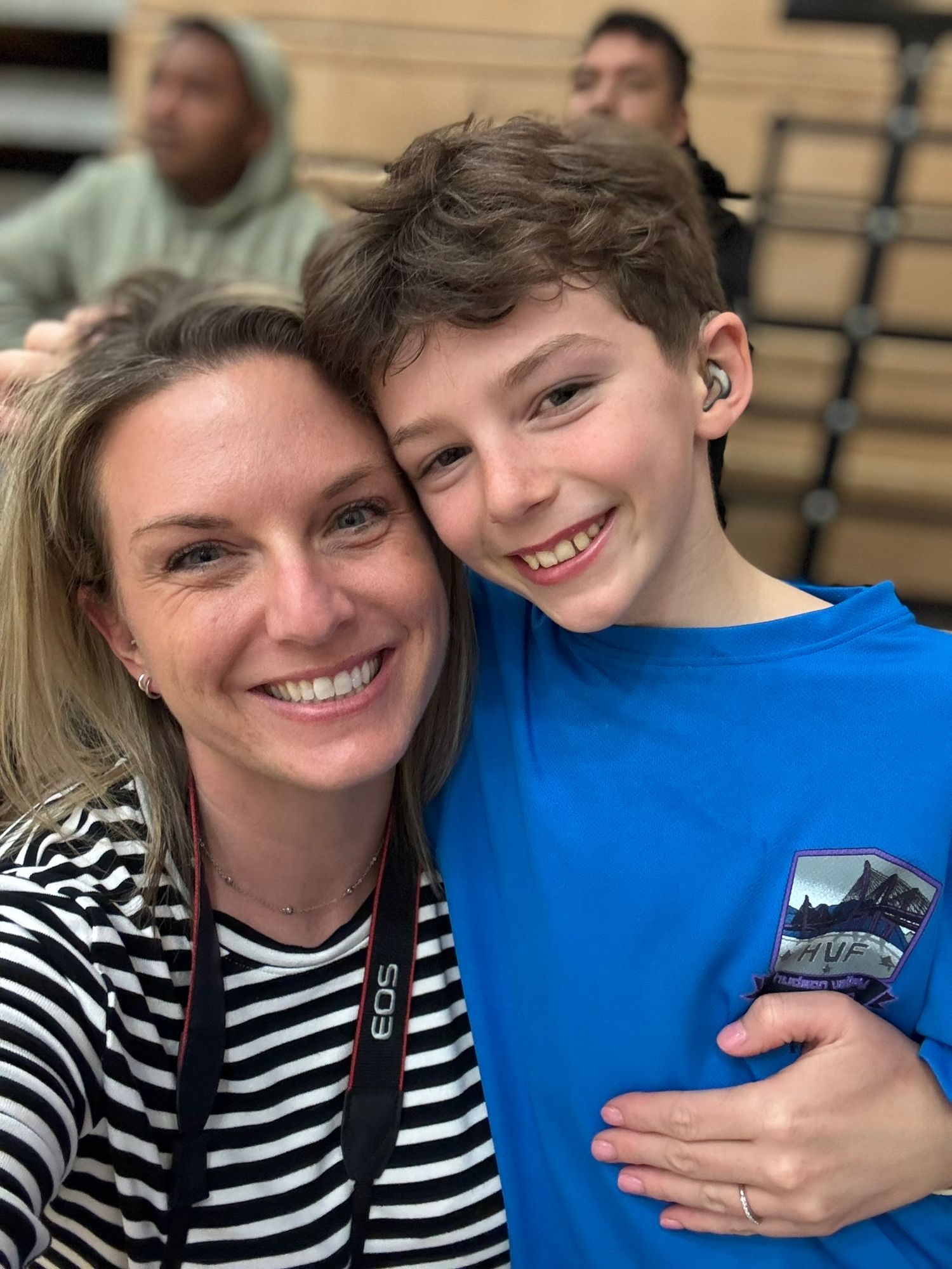 A mother and son embrace.