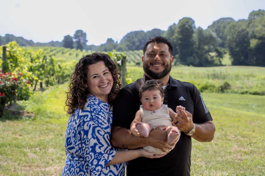 Family photo session in a scenic vineyard on a sunny summer day.