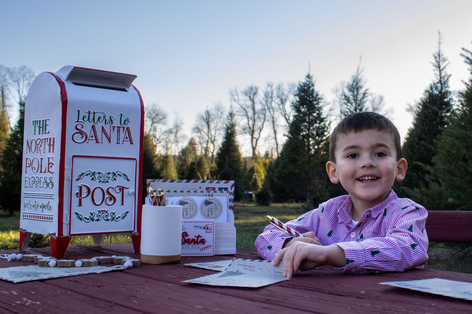 Letters to Santa display with red mailbox and decorative elements on wooden surface.