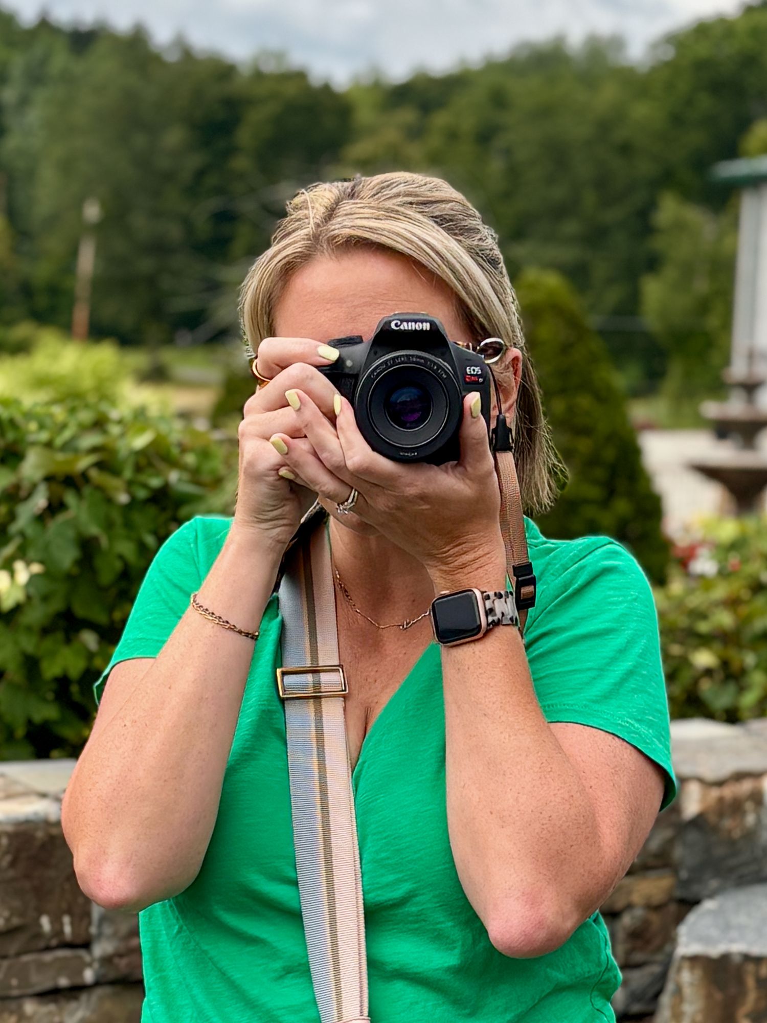 Photographer in bright green shirt taking pictures with a professional camera.
