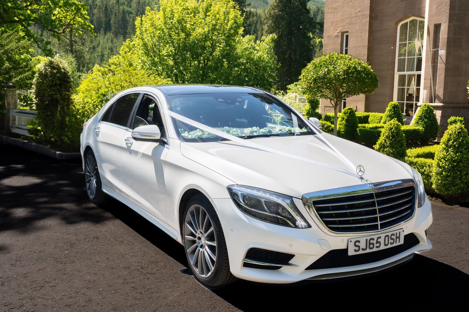 white Mercedes S class wedding car with white ribbon