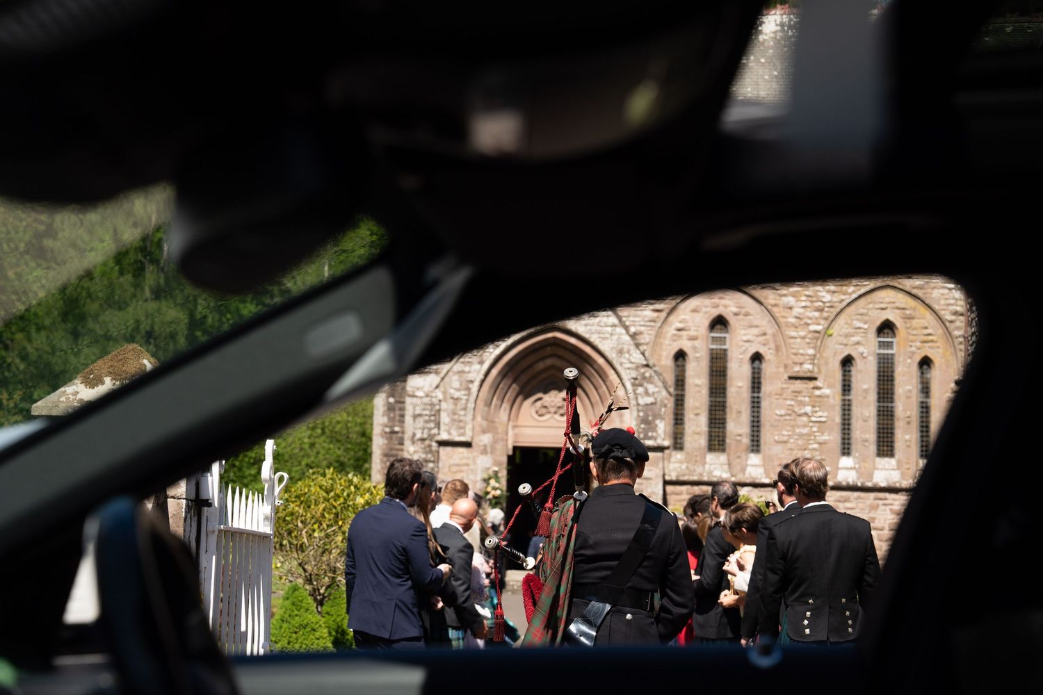Wedding guests seen through the window of a Mercedes wedding car