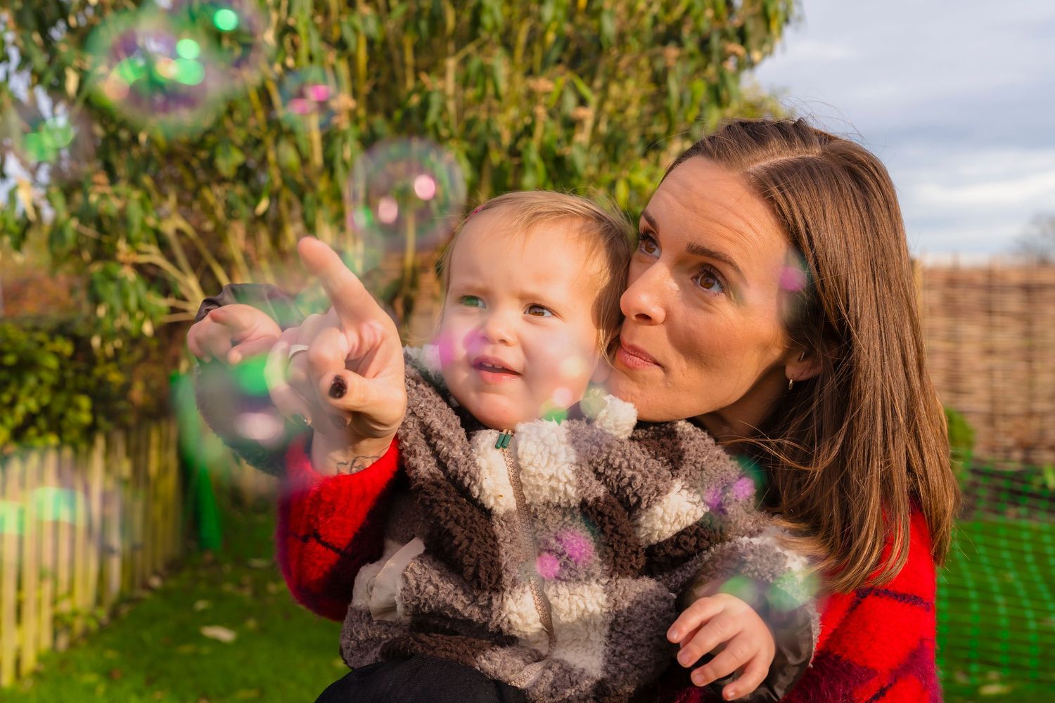 Mother and daughter playing with bubbles in the garden at an in home family session with shorely a memory.
