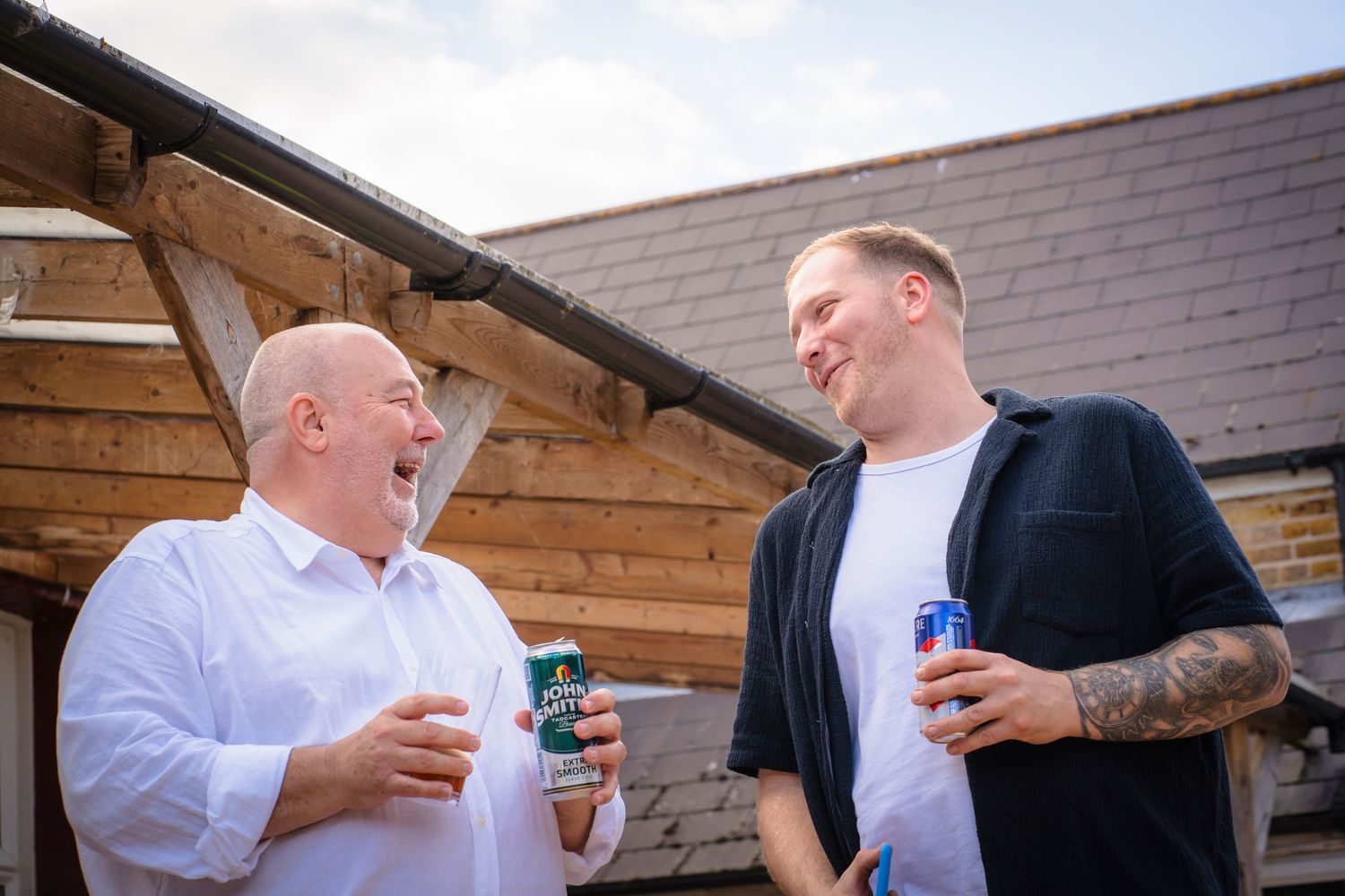 Father and son laughing and sharing a moment together at a family gathering.