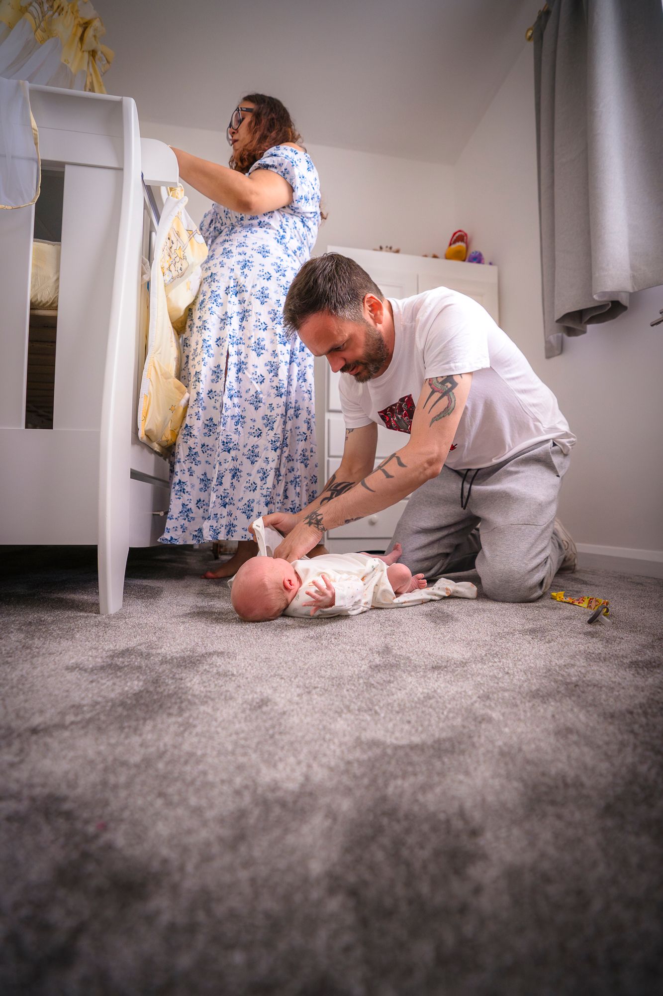in home candid photo session with a mother and father taking care of their new baby in the nursery.