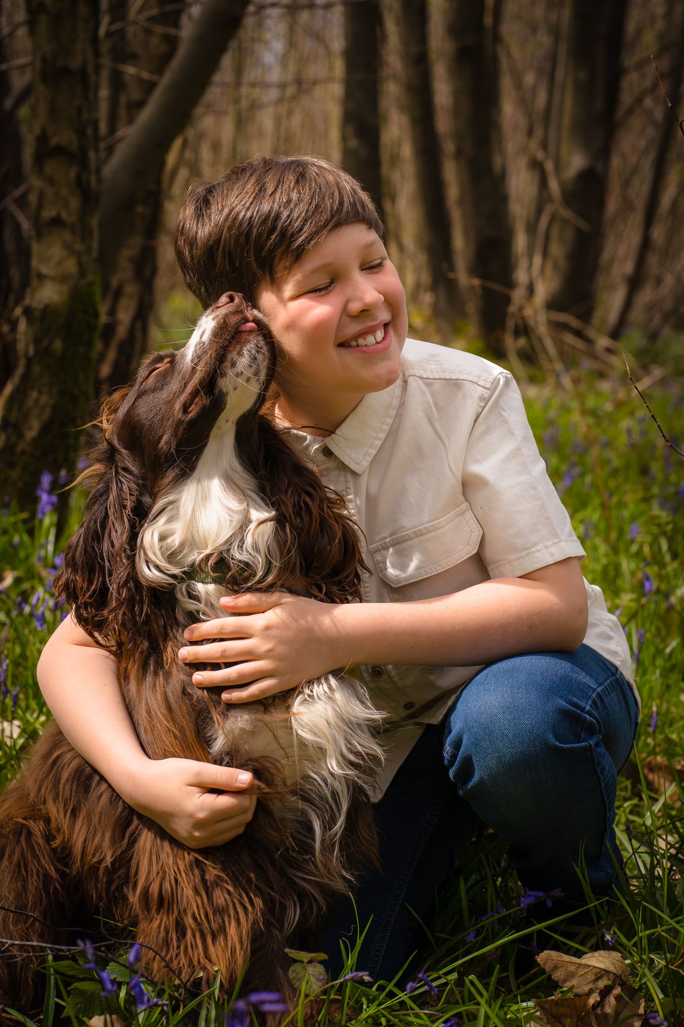 A young boy and his brown cocker spaniel having a hug at a woodland family photo session, real moments and real memories in Kent.
