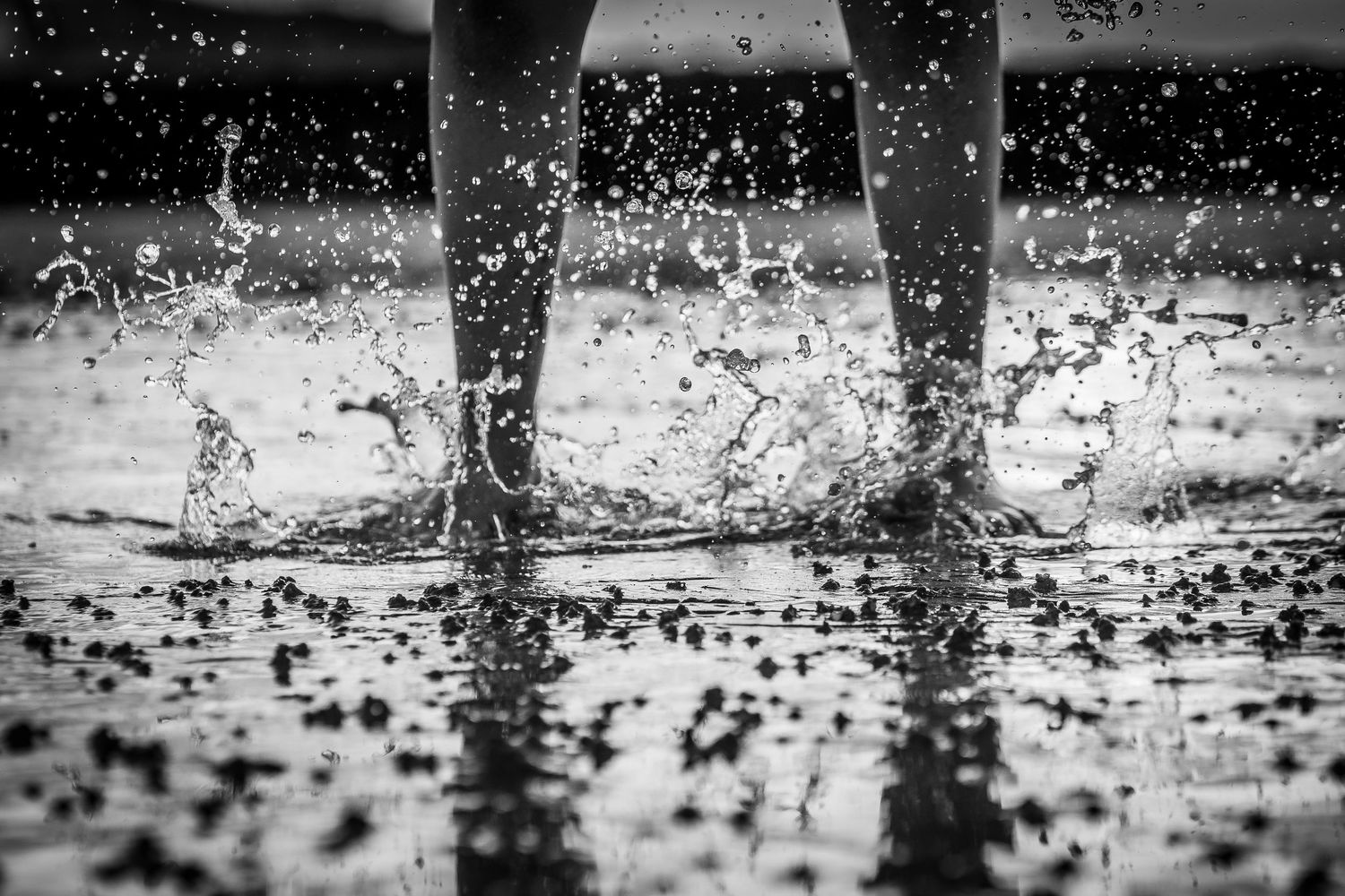 Two feet splashing on the beach in black and white at a photo session with SAM in Westgate beach, Kent.
