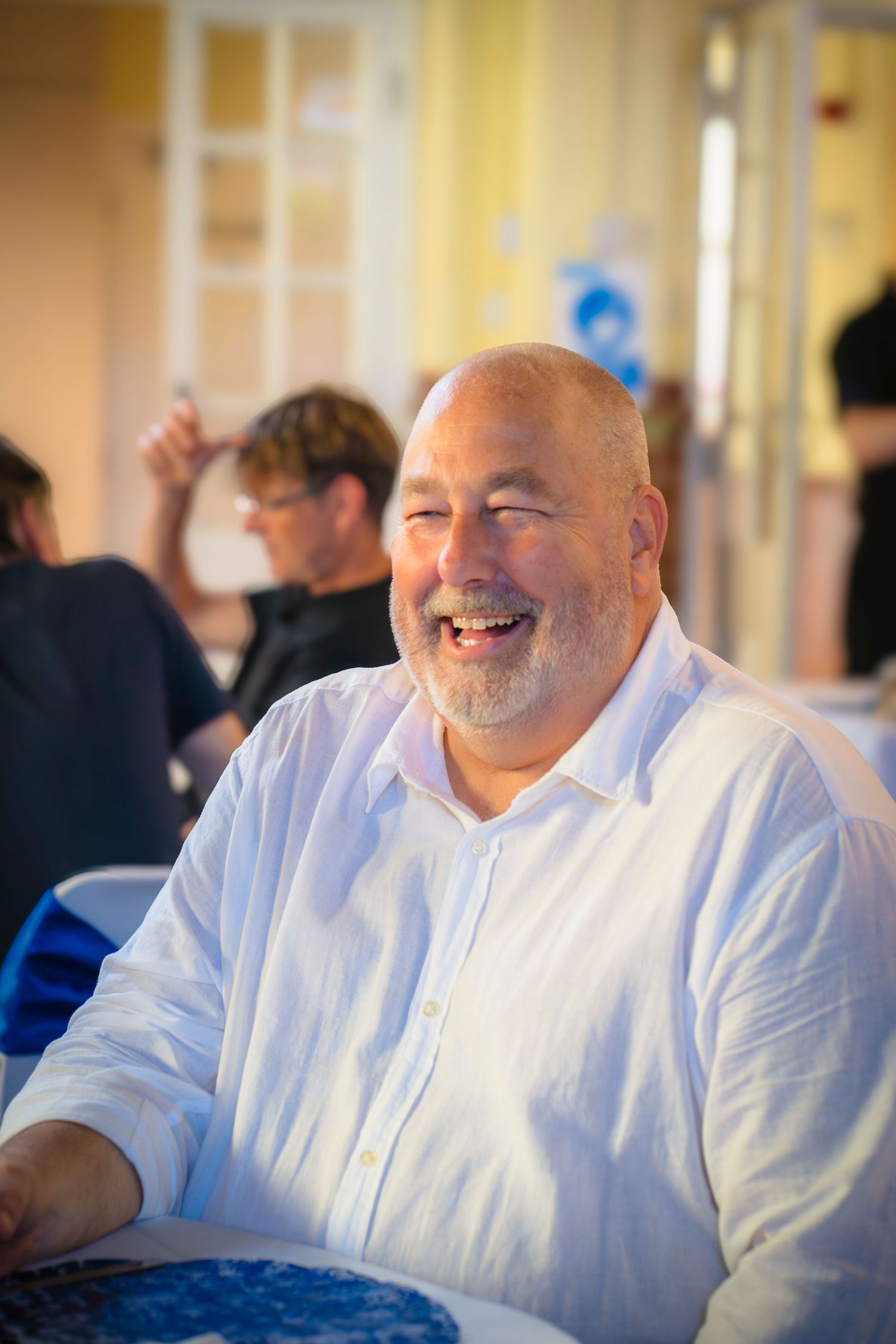 A man smiling at a celebration gathering, candid capture from shorely a memory