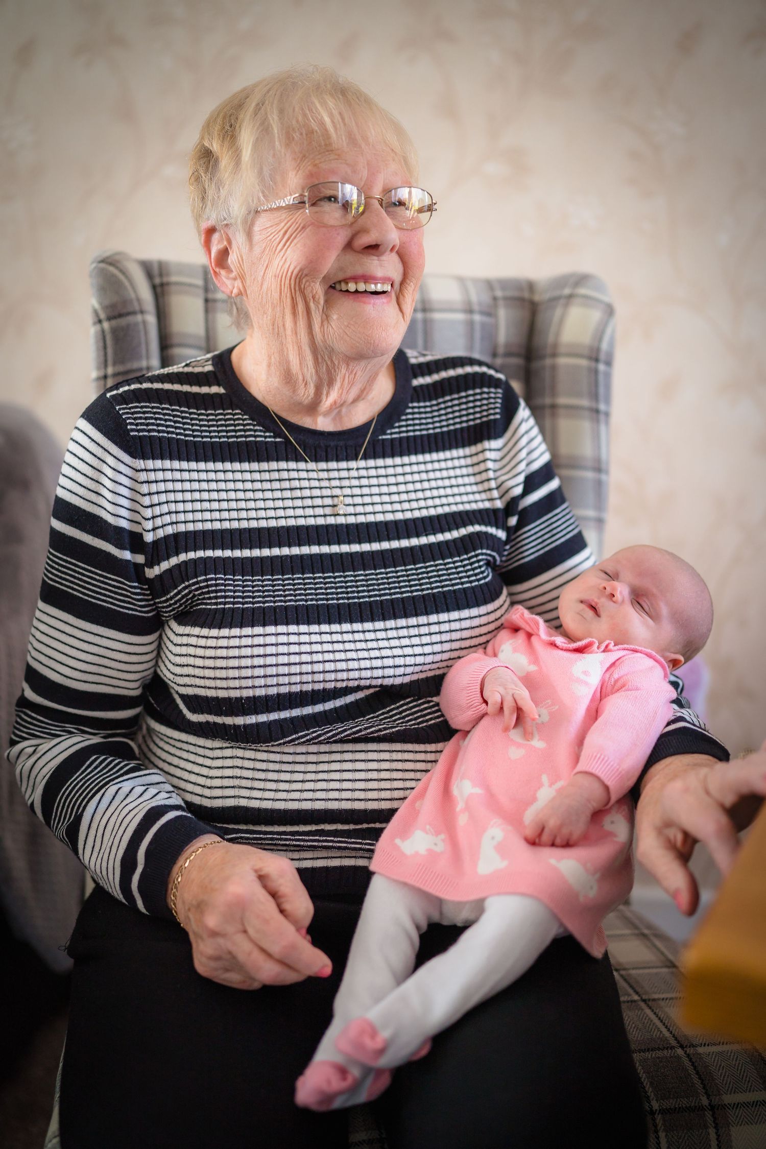 A great grandmother holding her new great granddaughter with a beautiful smile, happy moments and happy memories.