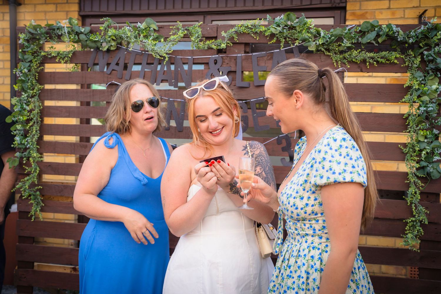 Three women all looking at some family photographs with the look of awe and love, capturing real emotions with shorely a memory photography