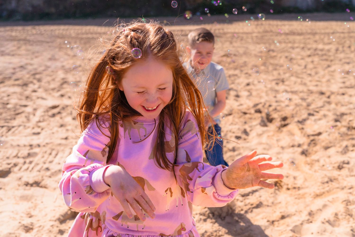 Sandy Thanet beach photo of two children playing with bubbles, running and laughing together, perfect candid moments with shorely a memory