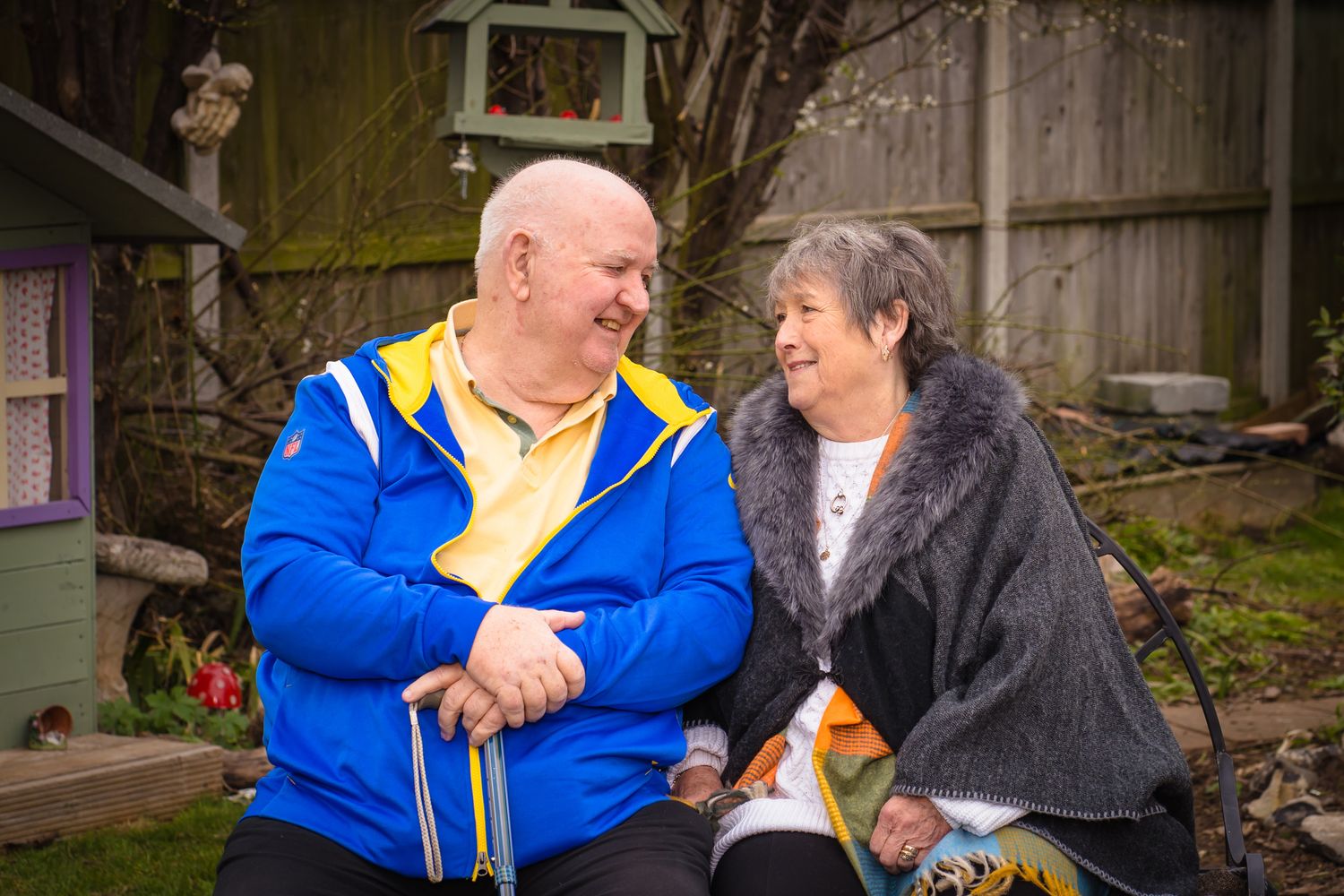 An elderly could looking into each others eyes in a park, no posing just genuine emotion.