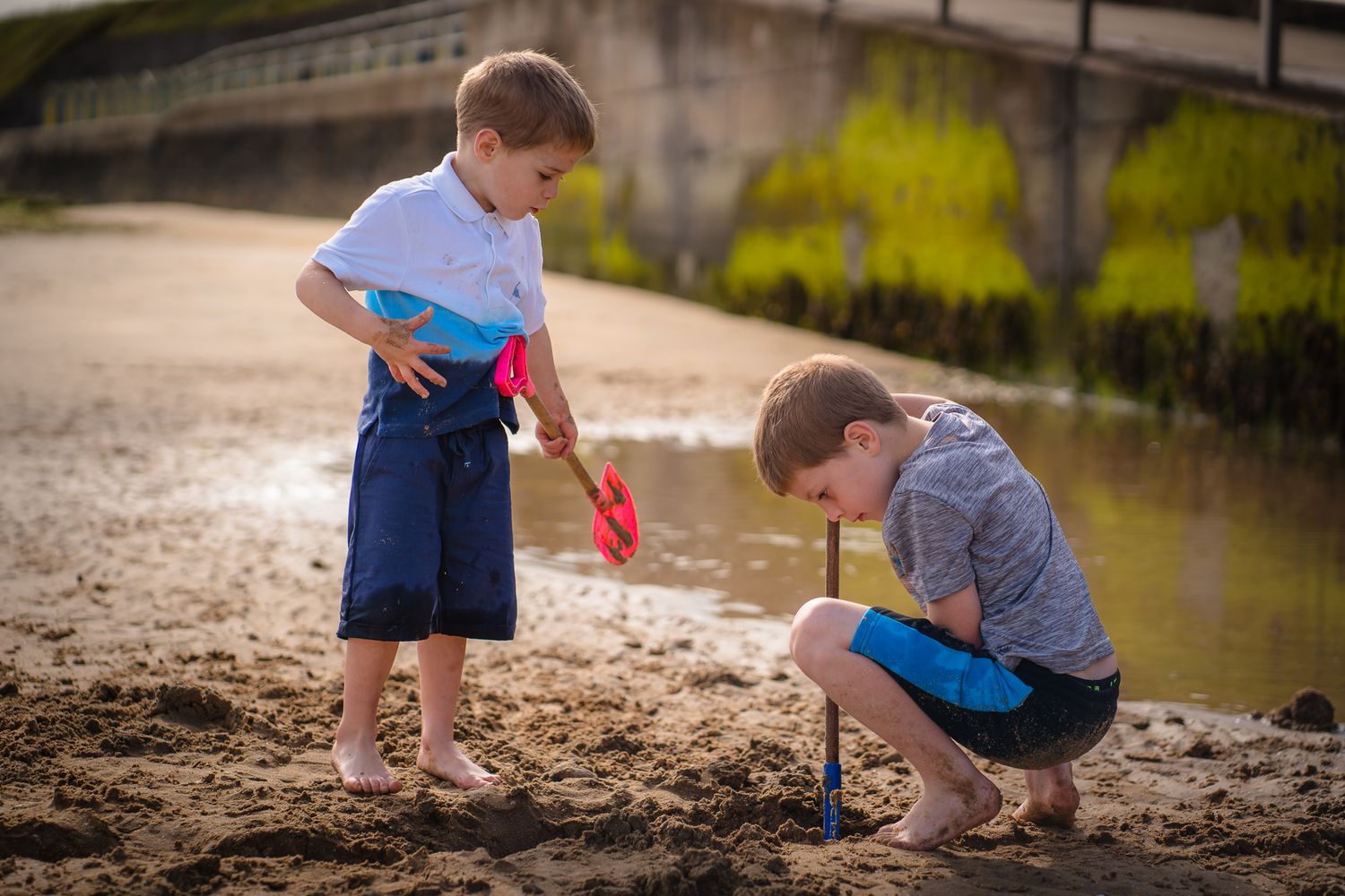 Two boys digging on Westgate beach near the water.