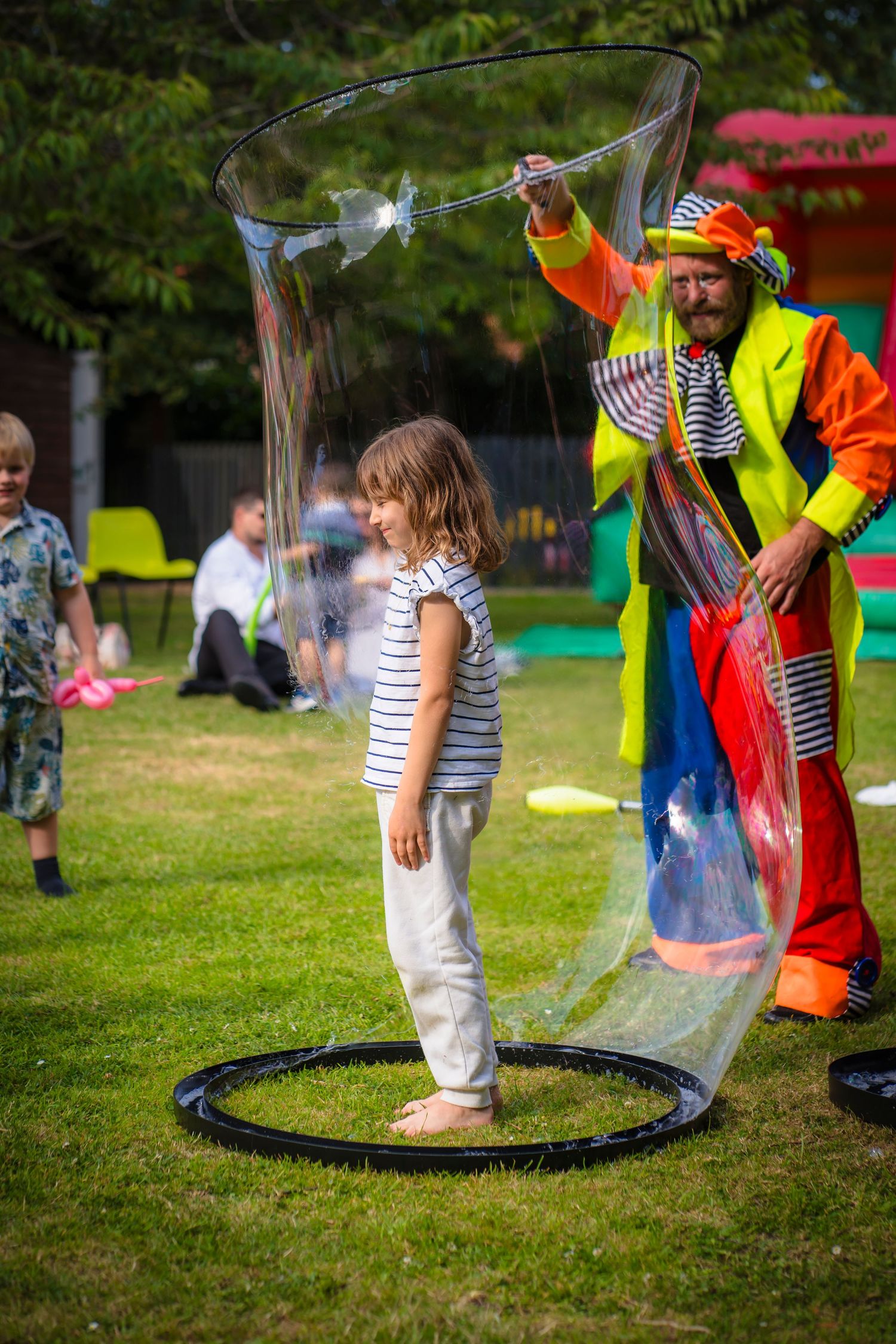 A girl in a clowns giant bubble at a celebration event captured by shorely a memory photography