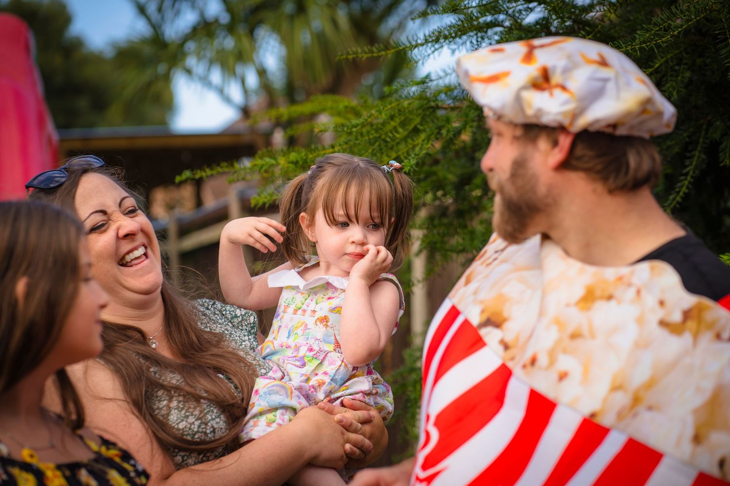 Party entertainer giving out popcorn to a family loving the entertainment. smiles and laughing showing the fun from the party.