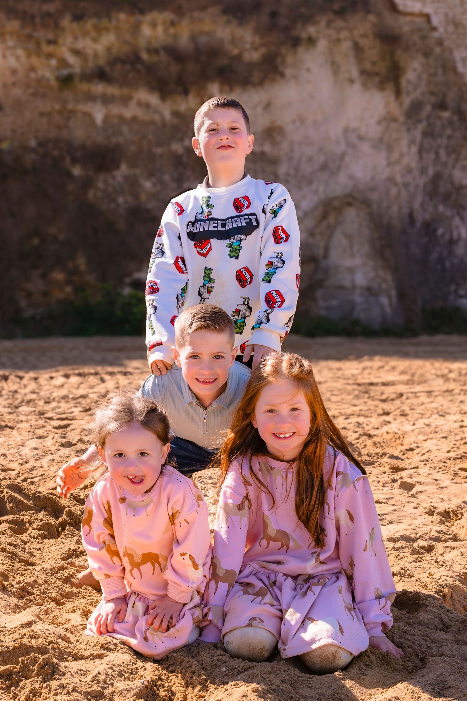 4 children portrait on sandy Margate beach with sunlight and candid moments.