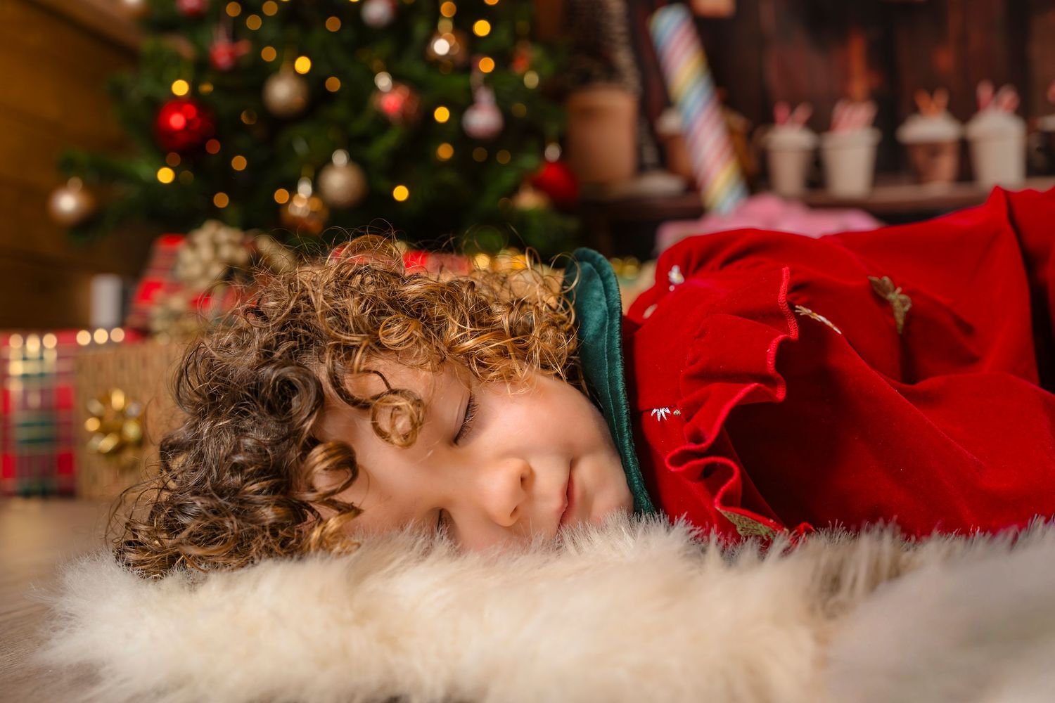 Curly hair and sleeping on the fur rug at her Christmas mini session with Shorely a Memory Photography in Margate, Kent.