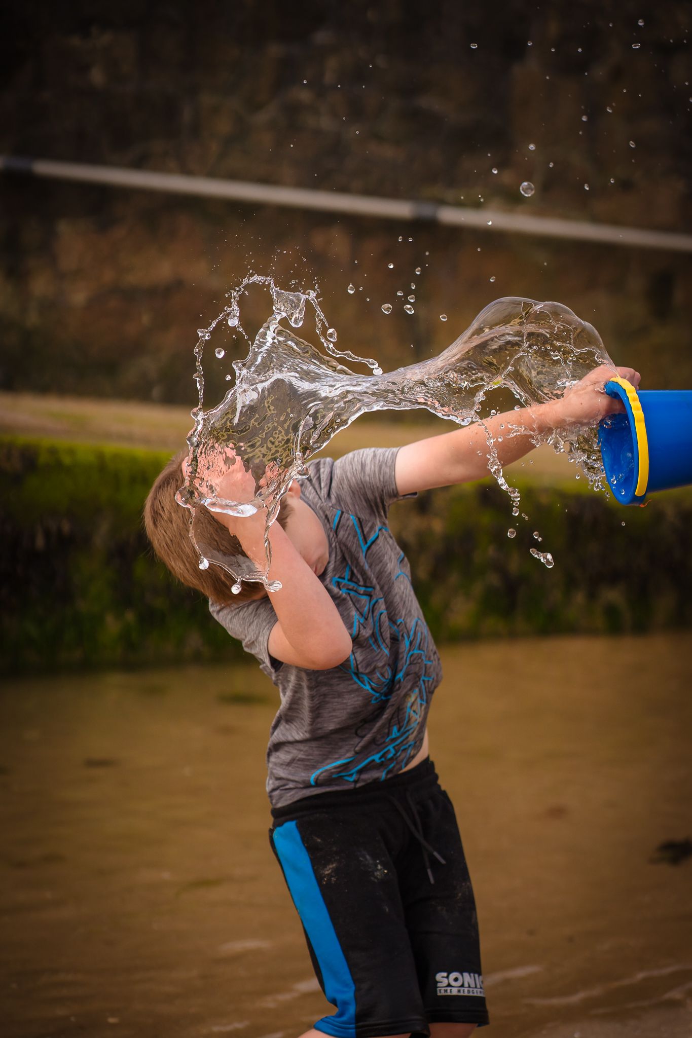 A boy slashing sea water over himself on a Margate beach.