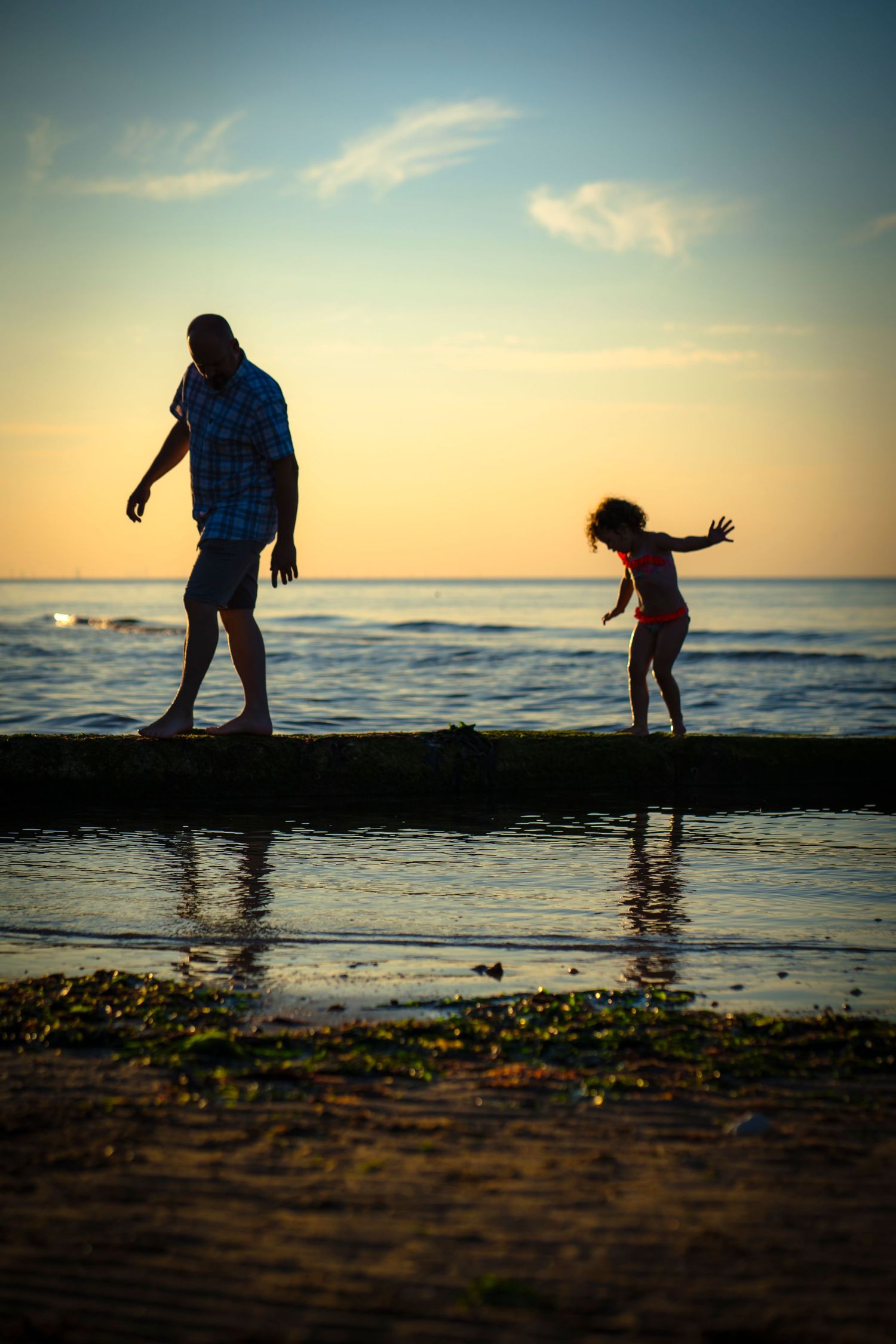 Silhouette beach scene with a father and daughter along the breakwater in Westgate on Sea in Kent with Shorely a Memory Photography