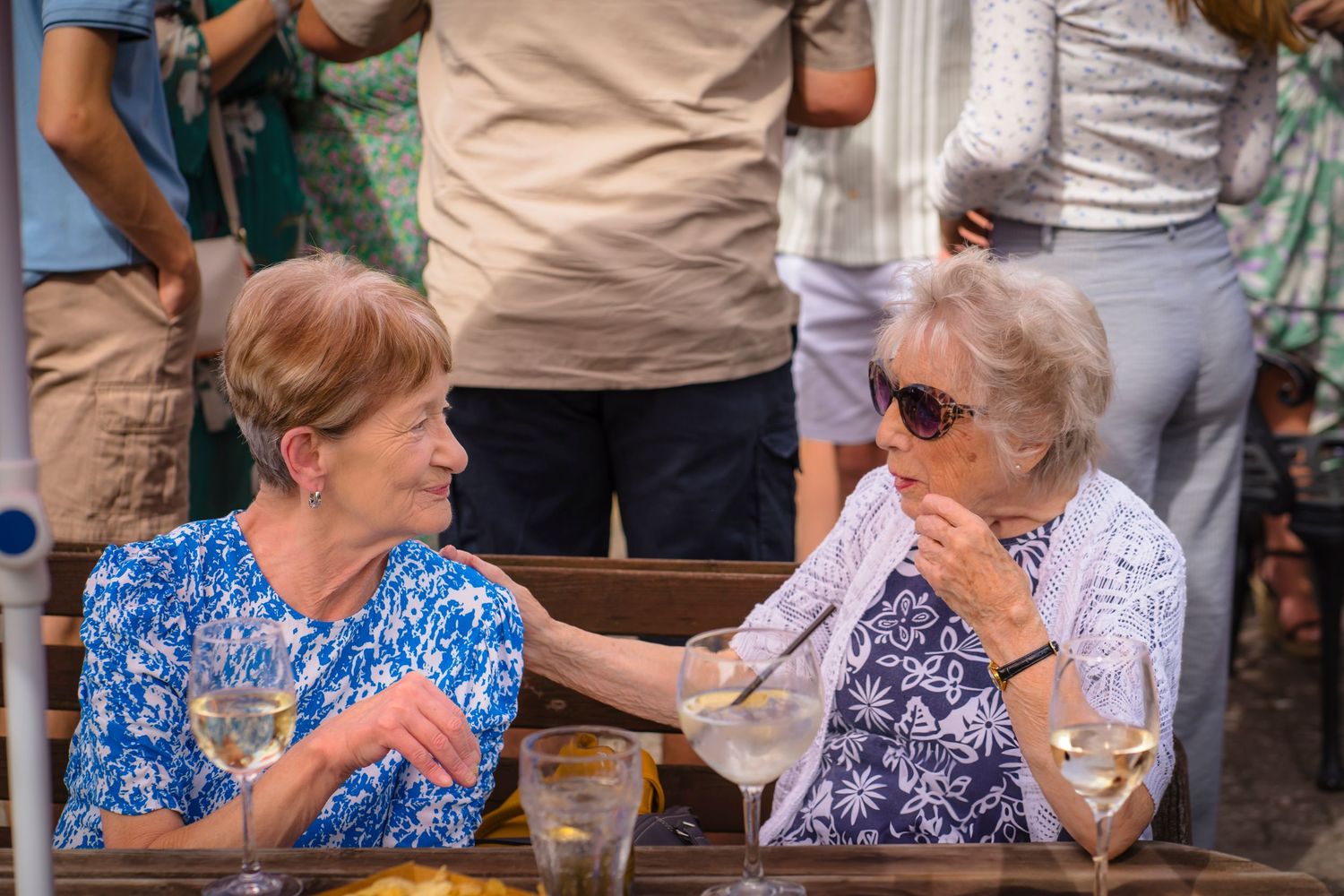 Two elderly grandmother's having a chat and a giggle at a family celebration, candid and unposed, real emotions that are to remember forever