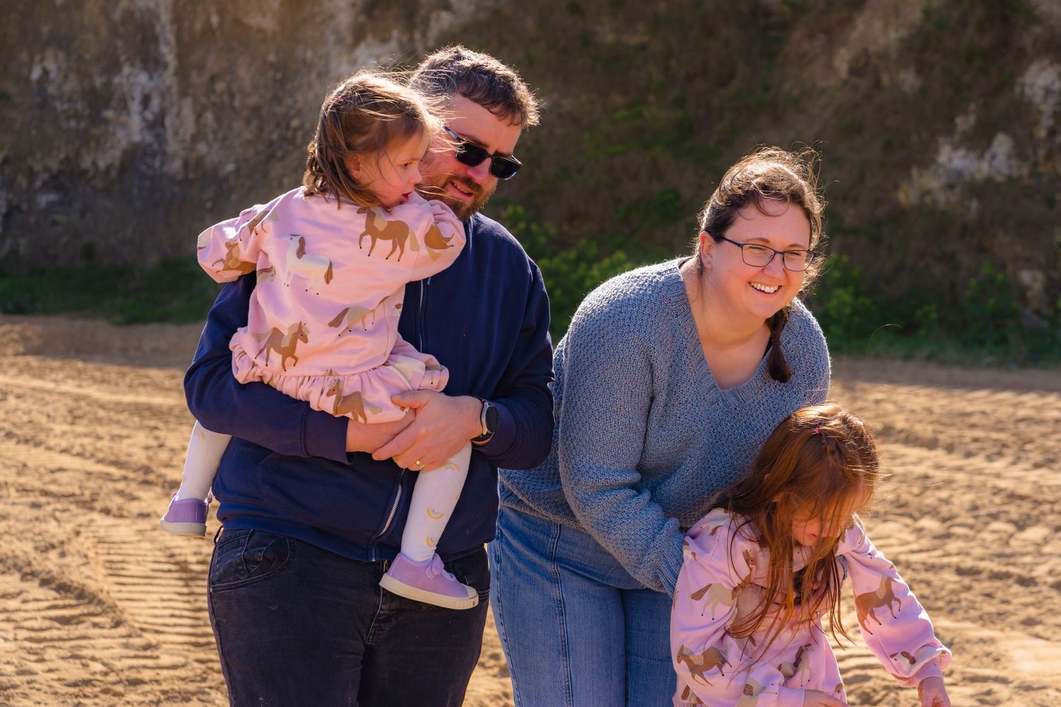 Beautiful candid image of a family of 4 playing on Thanet beaches with laughter and sunlight.