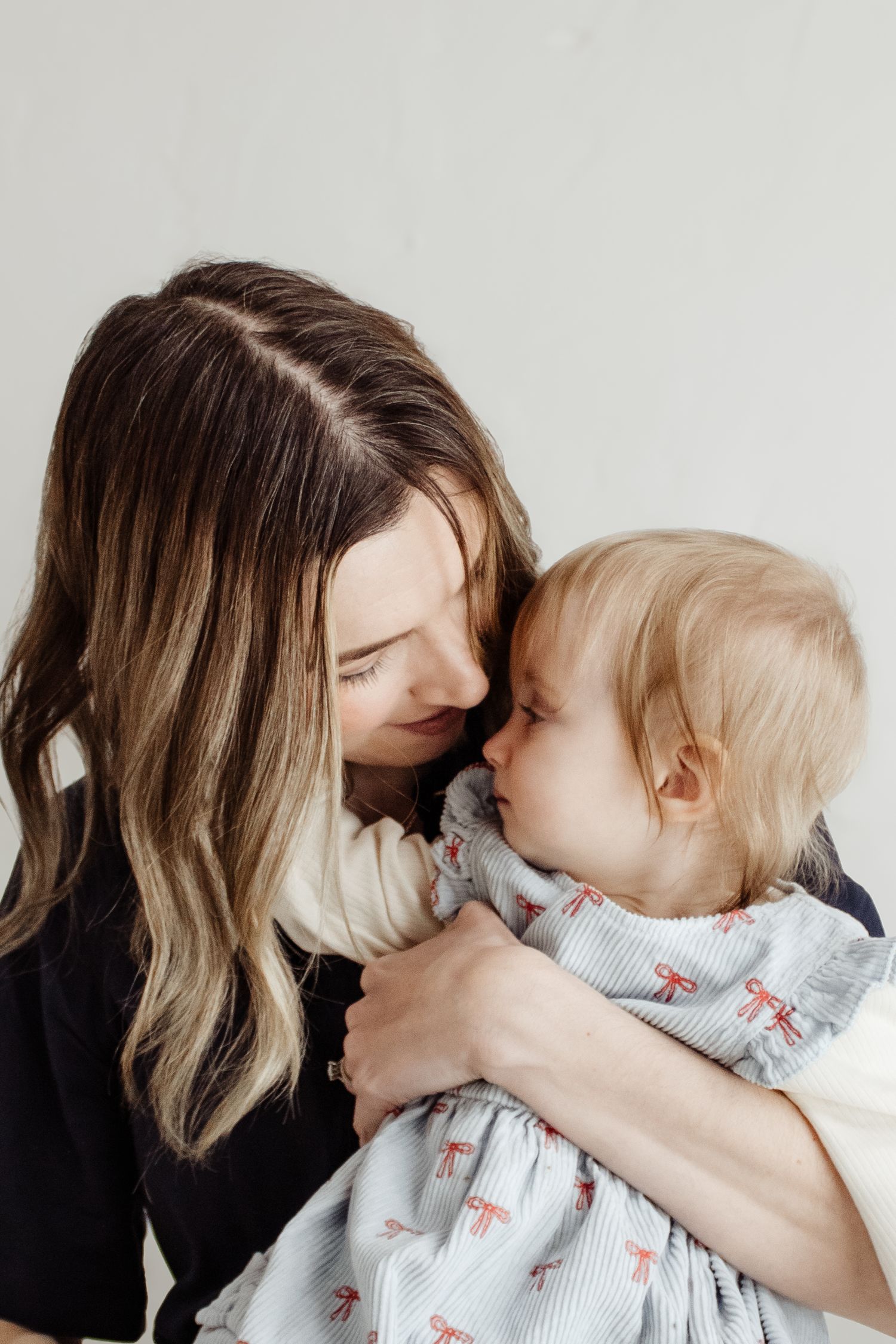 A series of intimate black and white photos showing a parent and child sharing tender moments together.