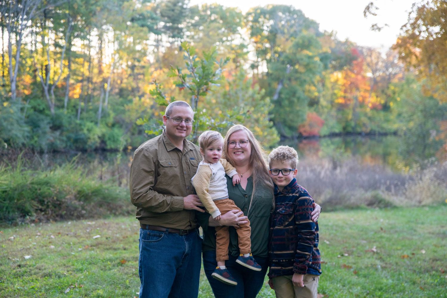Group photo taken in a scenic autumn setting with golden trees and natural landscape.