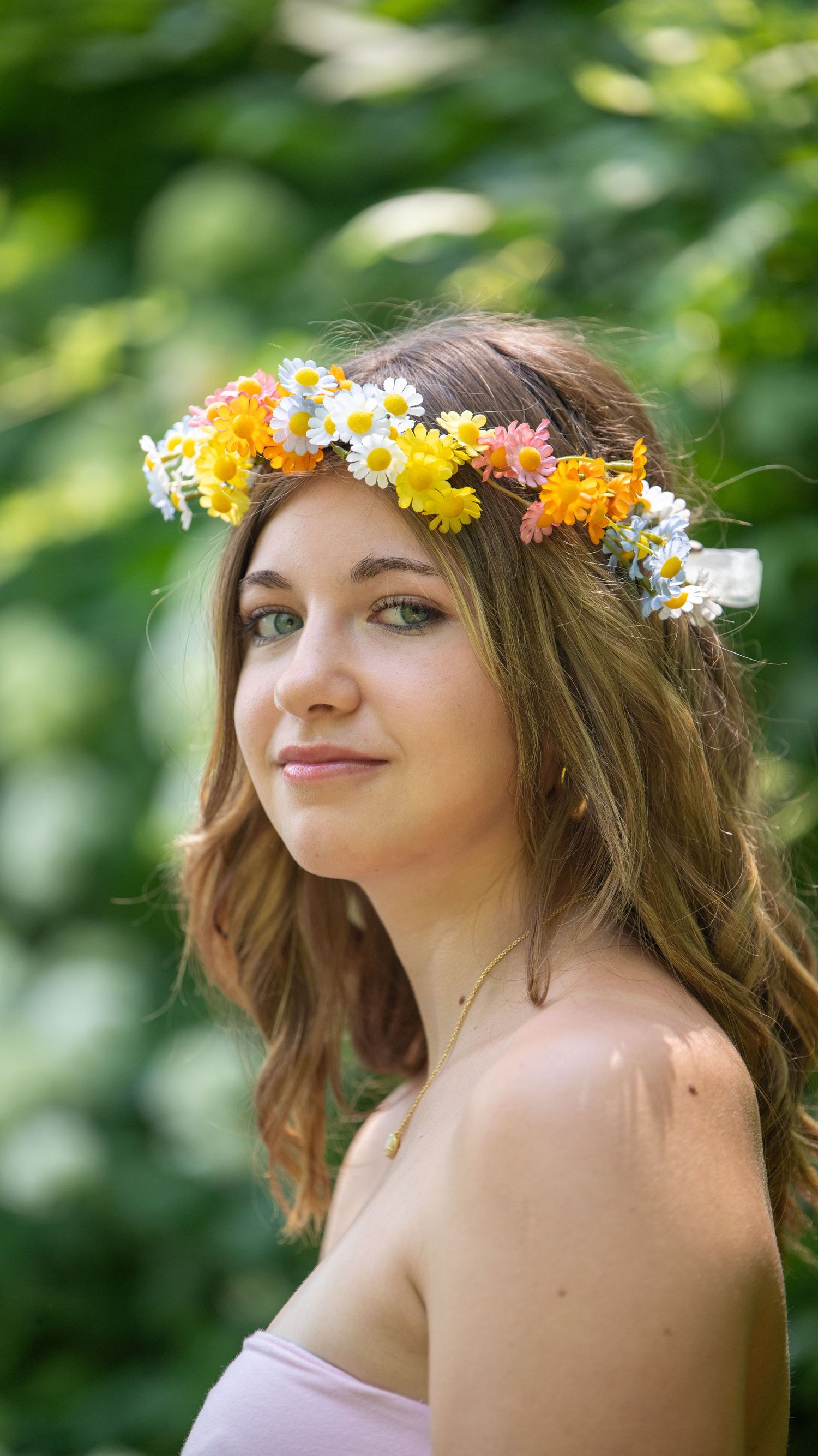 Close-up shots of a floral crown with yellow and white daisies against a blurred green background.