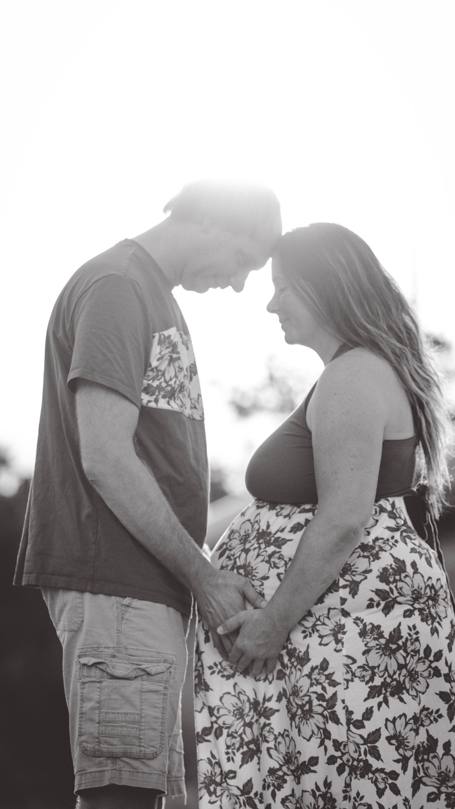Romantic black and white photo series showing couple embracing in silhouette against outdoor background.