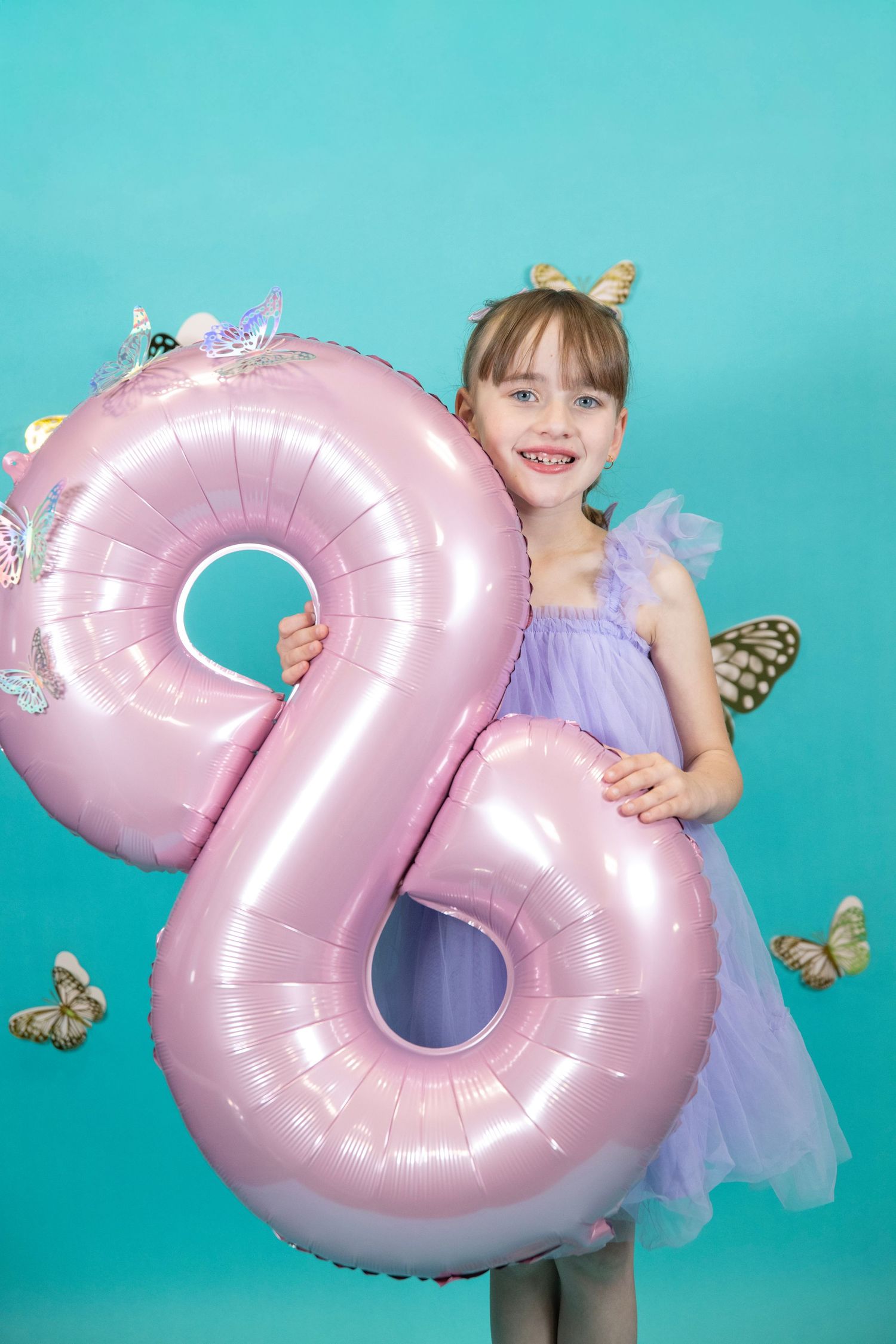 Festive scene with large pink number 2 balloon and butterfly accents.