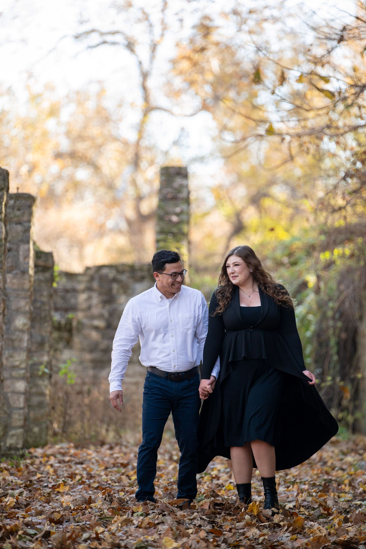 Couple explores stone ruins together during autumn photoshoot.