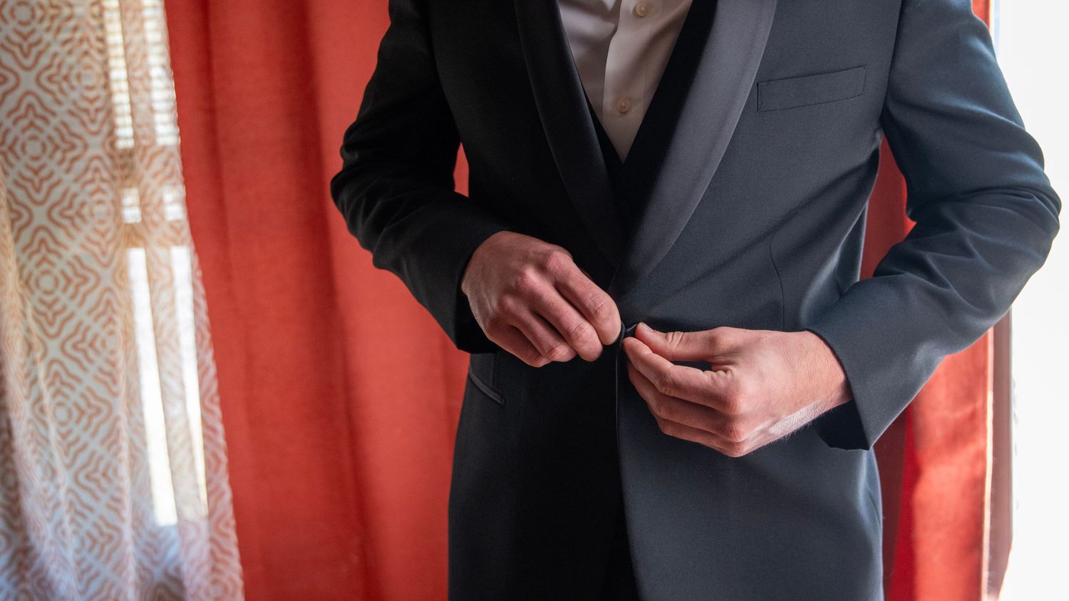 Close-up detail shots of men in formal suits with red accents preparing for a special occasion.