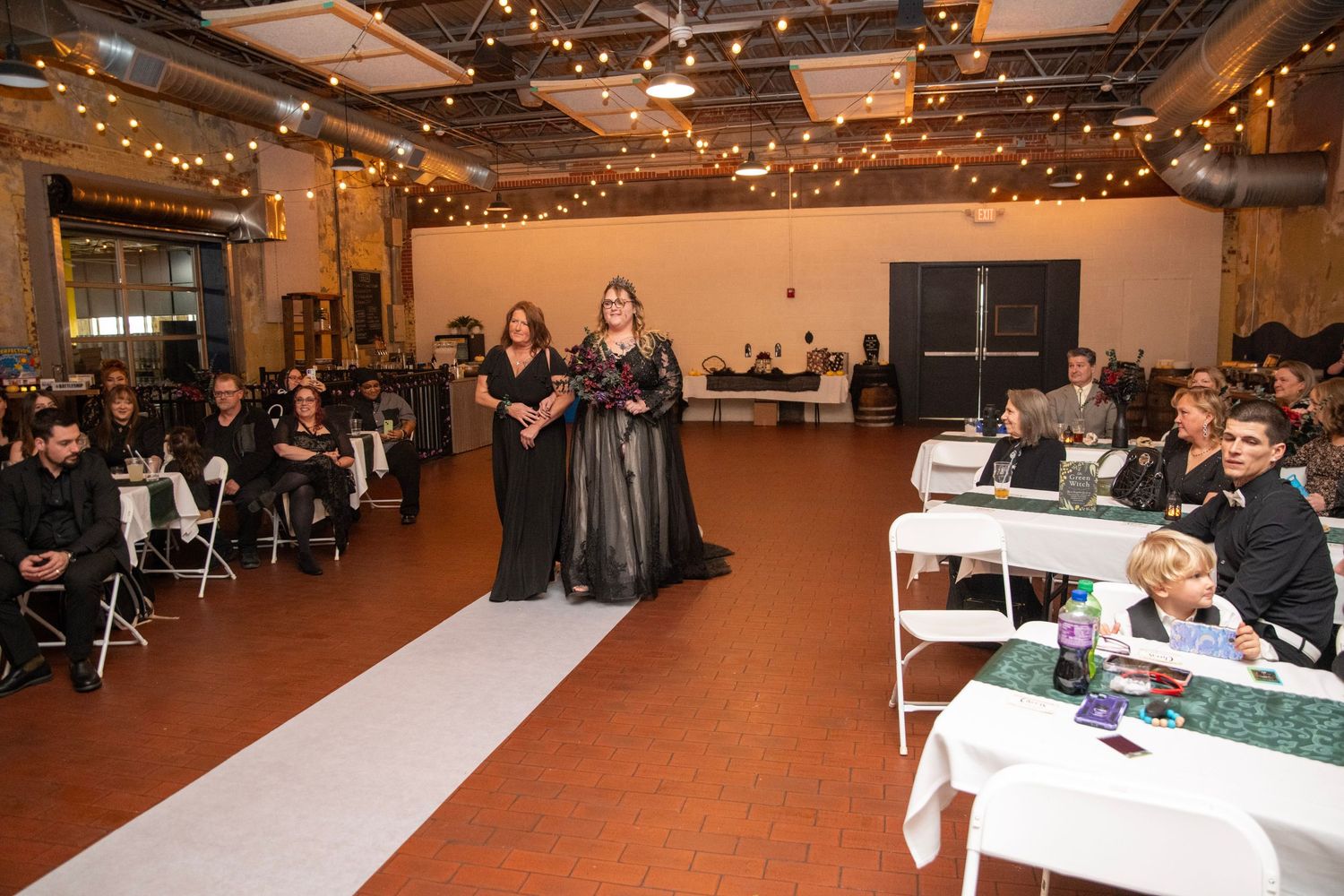 Large indoor venue with warm lighting and tables set for an evening event.
