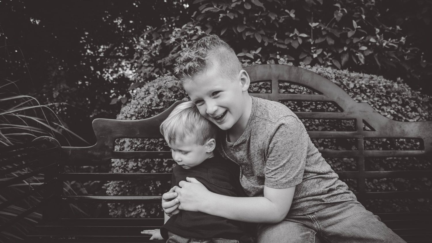 A black and white panoramic series showing two people sitting together outdoors.